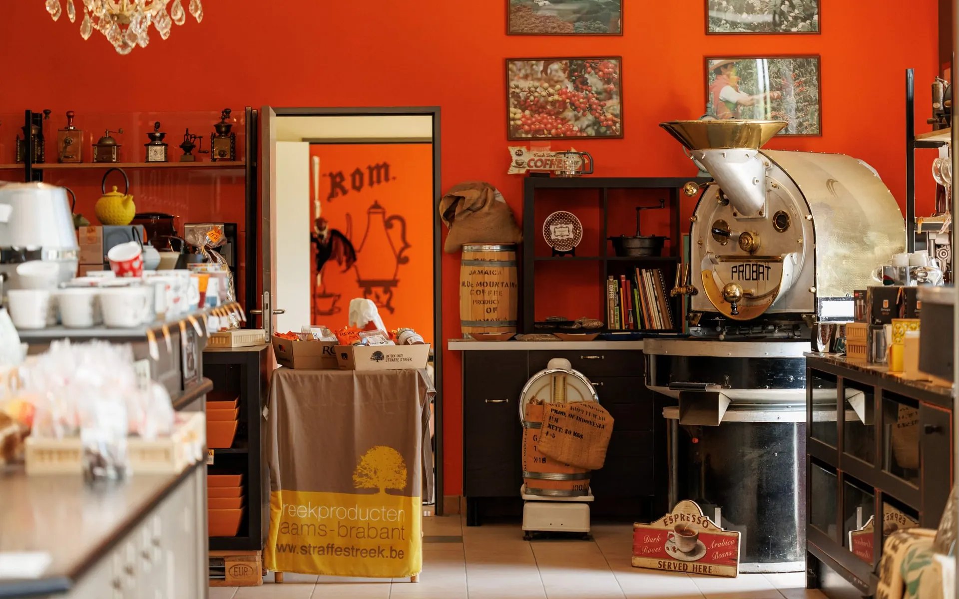 De winkel en branderij van ROM Koffie met de antieke Probat-brander tegen de oranjerode muur