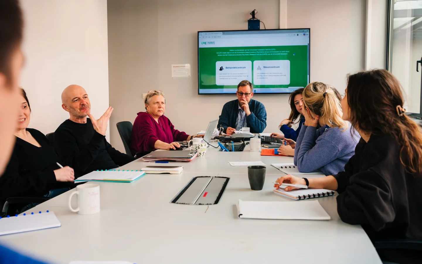 Het UFC-team in overleg met de nieuwe website op het vergaderscherm