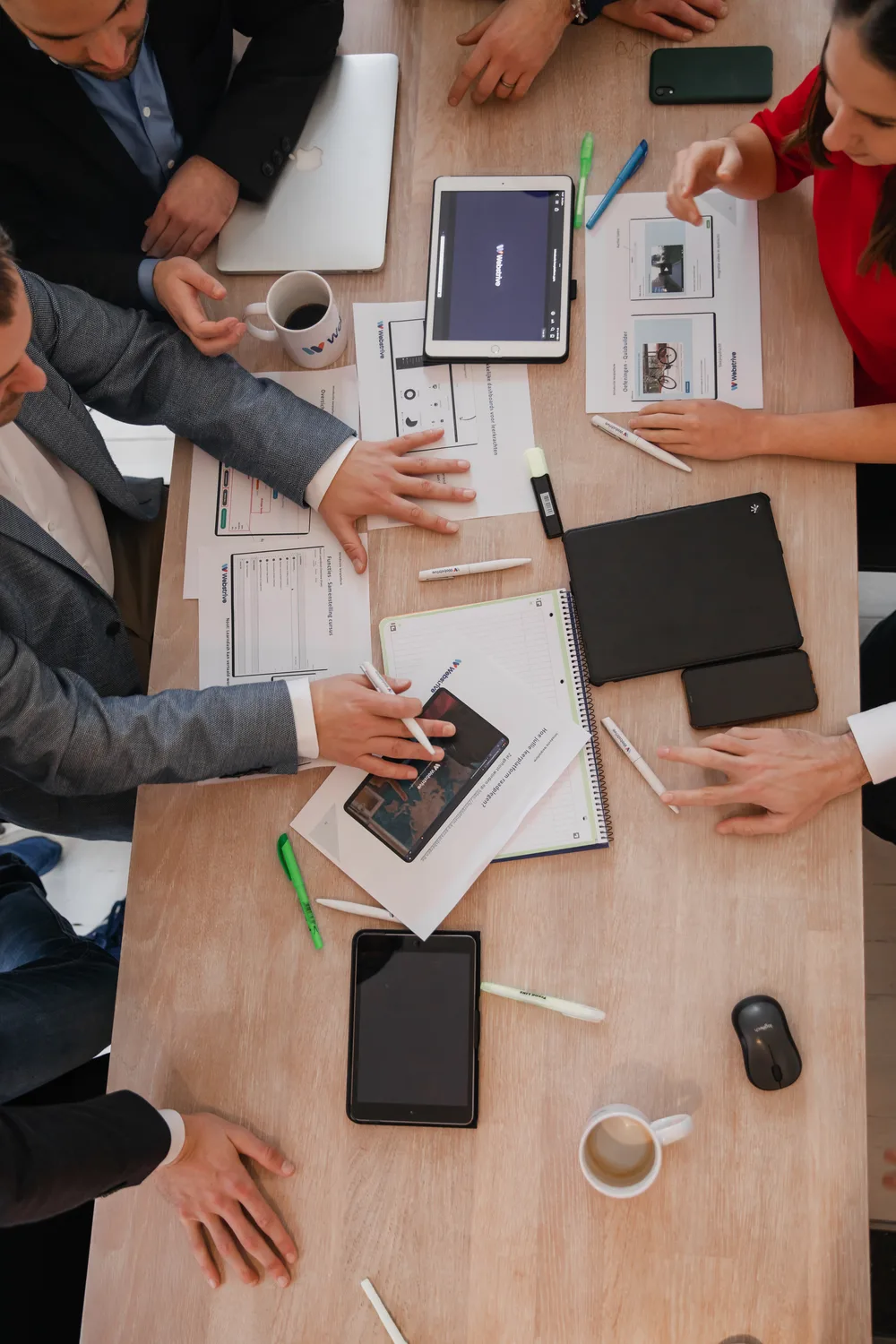 Werktafel bij Webstrive met schetsen, tablets en projectdocumenten